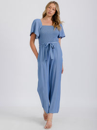 WOMEN'S SHORT SLEEVE SMOCKED FRONT POCKET BELTED CHAMBRAY JUMPSUIT